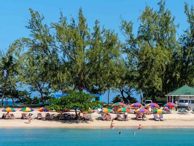 Beach at Pigeon Island National Landmark with colorful umbrellas and people relaxing.